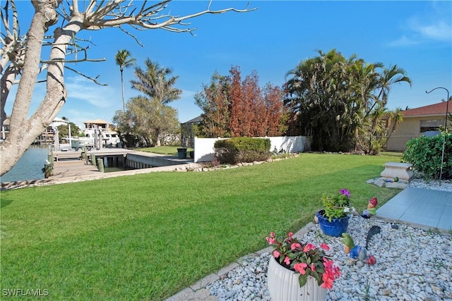 view of yard featuring a water view and a dock