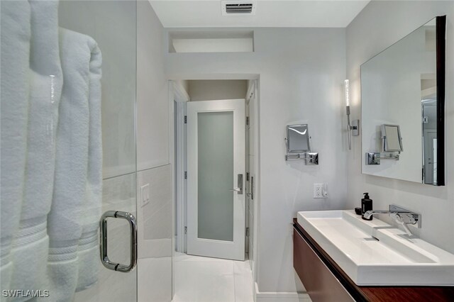 bathroom with tile patterned flooring, vanity, and a shower with shower door