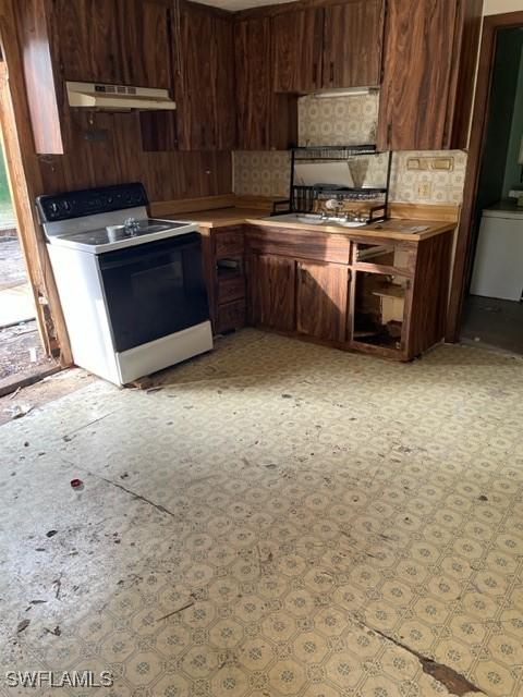 kitchen with electric range, sink, washer / dryer, and dark brown cabinetry