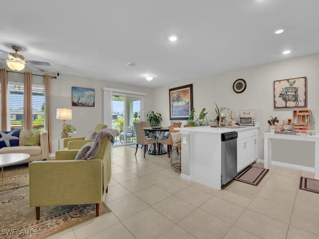 kitchen with ceiling fan, dishwasher, sink, light tile patterned flooring, and white cabinets