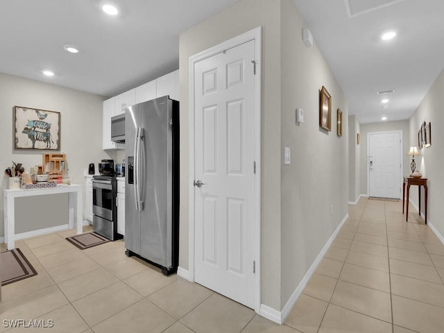 kitchen with white cabinetry, stainless steel appliances, and light tile patterned flooring