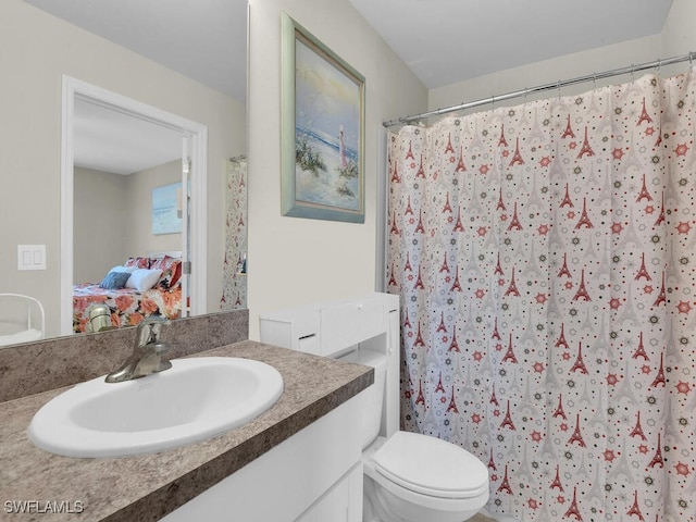 bathroom with toilet, vanity, and a shower with shower curtain