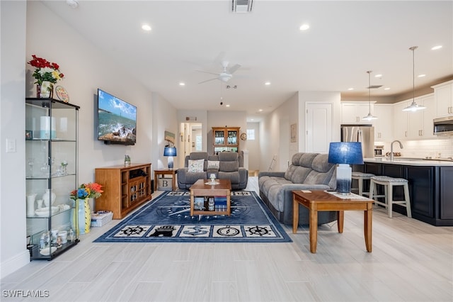 living room featuring ceiling fan and sink