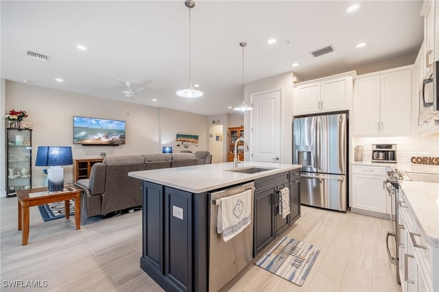 kitchen with ceiling fan, stainless steel appliances, white cabinetry, and sink