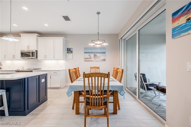 dining space with sink and an inviting chandelier