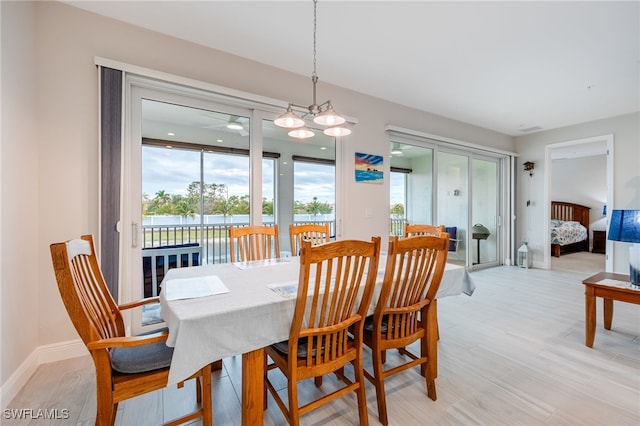 dining area featuring light wood-type flooring, a wealth of natural light, and a chandelier