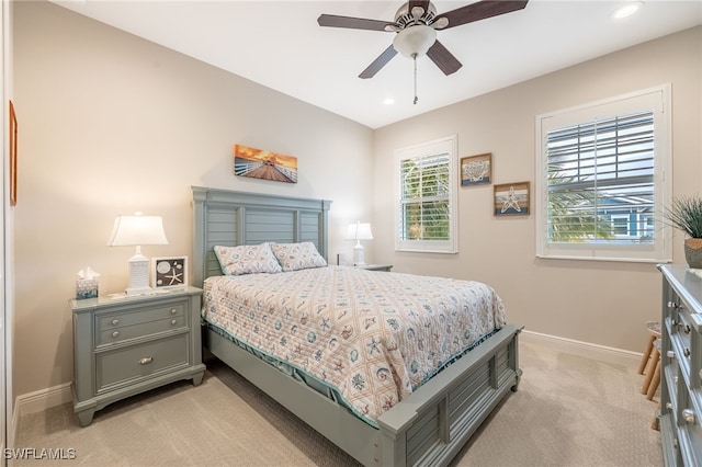 carpeted bedroom featuring ceiling fan and multiple windows