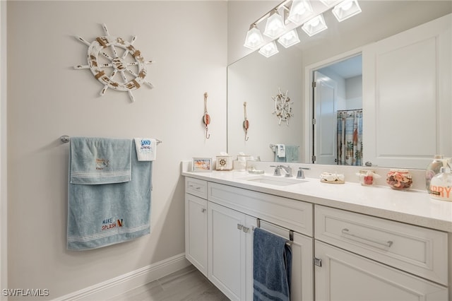 bathroom featuring walk in shower and vanity