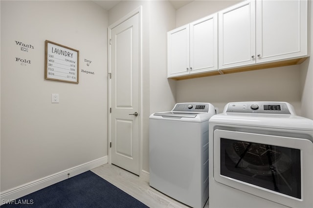 laundry area with light hardwood / wood-style flooring, independent washer and dryer, and cabinets