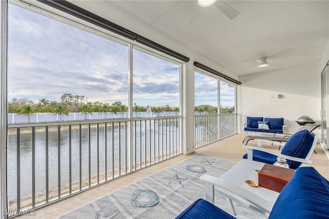 sunroom / solarium with a water view and ceiling fan