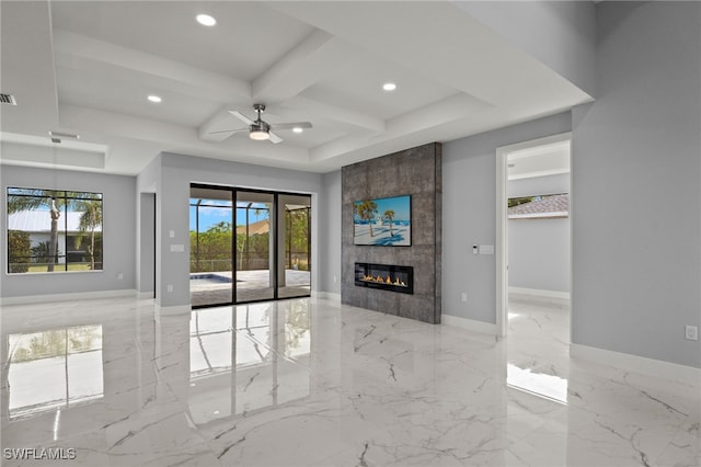 unfurnished living room with a fireplace, coffered ceiling, ceiling fan, and a wealth of natural light