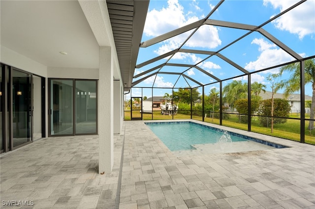 view of swimming pool featuring glass enclosure, a patio area, a lawn, and pool water feature