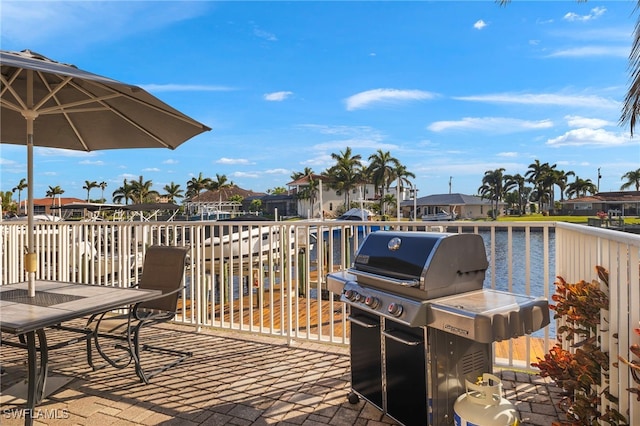 wooden terrace with a grill and a water view