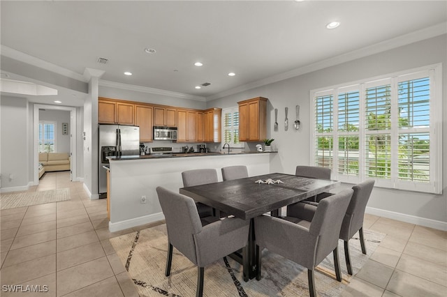 dining space featuring light tile patterned floors, crown molding, and sink