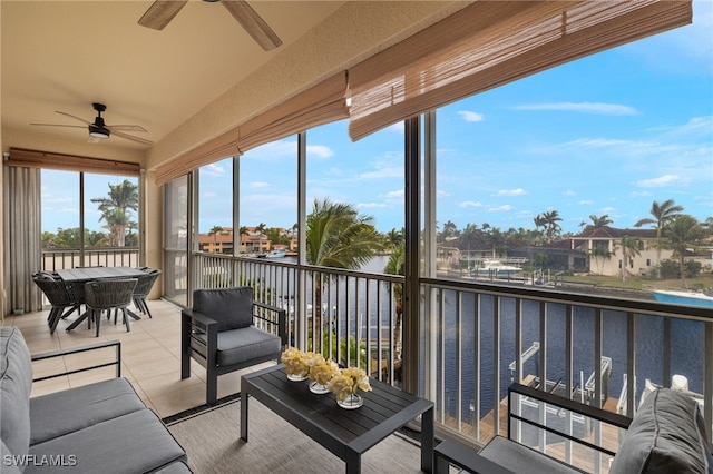 sunroom / solarium with a water view and ceiling fan