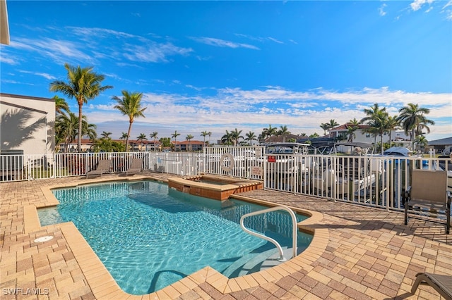 view of swimming pool featuring a patio area and a hot tub