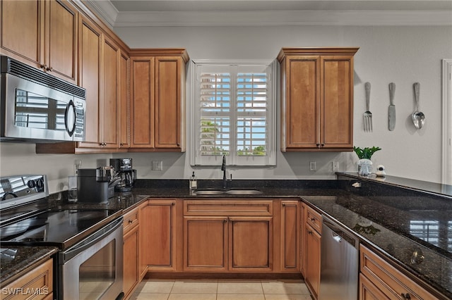 kitchen featuring sink, crown molding, light tile patterned floors, appliances with stainless steel finishes, and dark stone counters