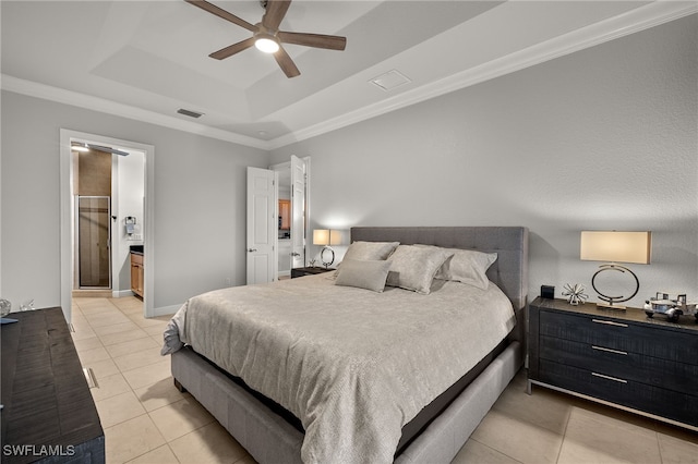 bedroom featuring crown molding, light tile patterned floors, ensuite bathroom, and a tray ceiling