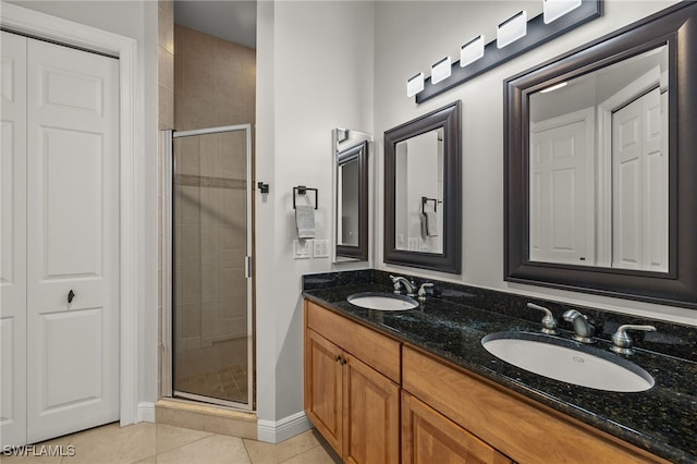 bathroom with a shower with door, vanity, and tile patterned floors