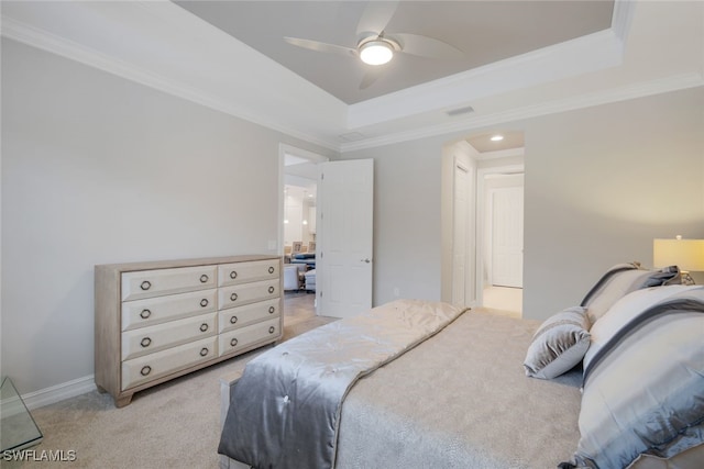 bedroom with ceiling fan, light colored carpet, ornamental molding, and a tray ceiling