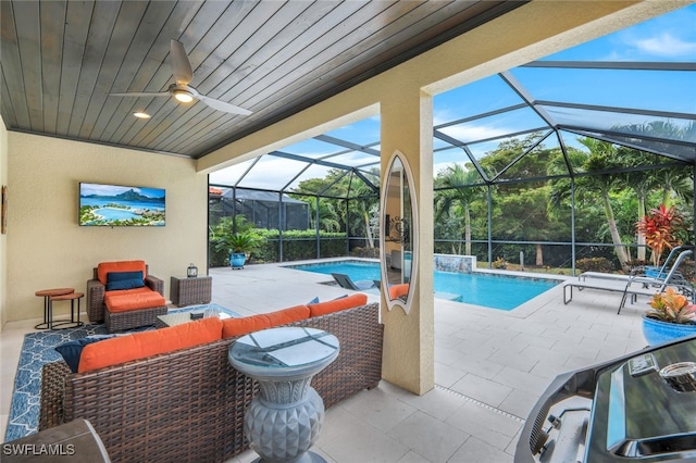 view of swimming pool with an outdoor hangout area, a patio, glass enclosure, and ceiling fan