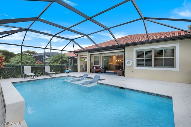 view of pool with glass enclosure and a patio