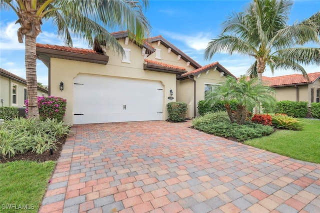 mediterranean / spanish-style home with central AC unit and a garage