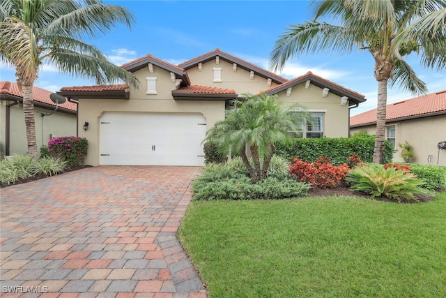 mediterranean / spanish home featuring a front yard and a garage