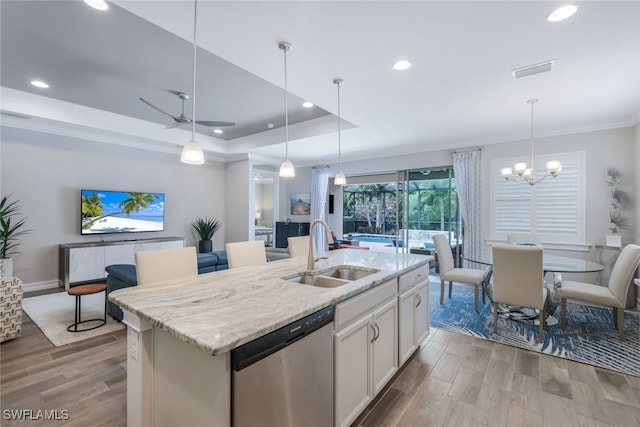 kitchen featuring sink, a center island with sink, a raised ceiling, and dishwasher