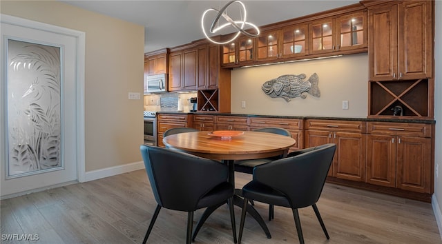 dining room featuring light wood-type flooring and a notable chandelier