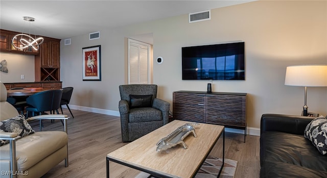 living room with hardwood / wood-style floors and a notable chandelier