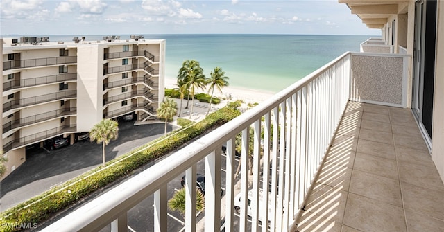 balcony with a water view and a view of the beach