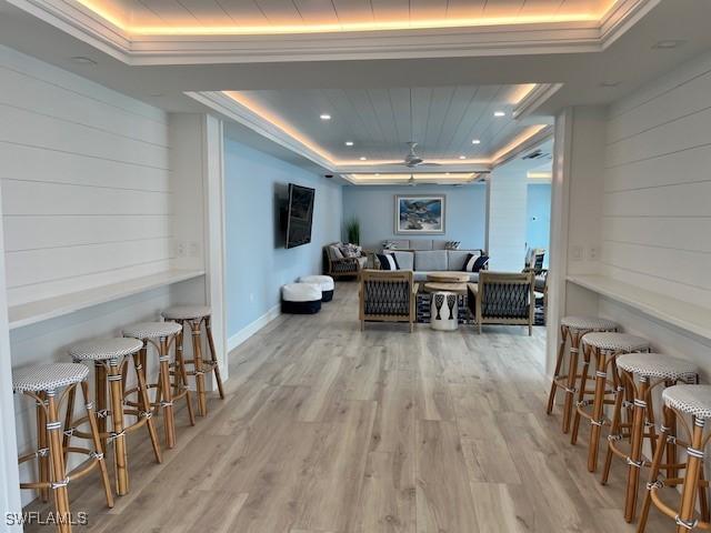 interior space with a raised ceiling and light hardwood / wood-style flooring