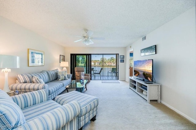 living room with visible vents, baseboards, light colored carpet, a textured ceiling, and a ceiling fan