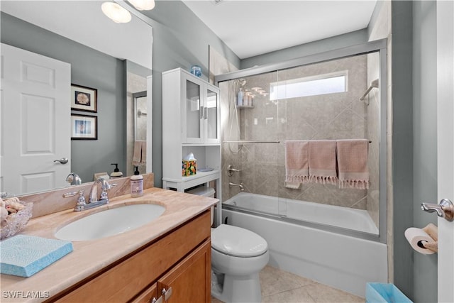 full bathroom featuring toilet, bath / shower combo with glass door, vanity, and tile patterned floors