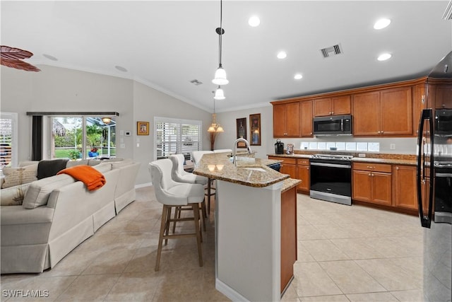 kitchen featuring black refrigerator, decorative light fixtures, stainless steel electric stove, light stone countertops, and sink