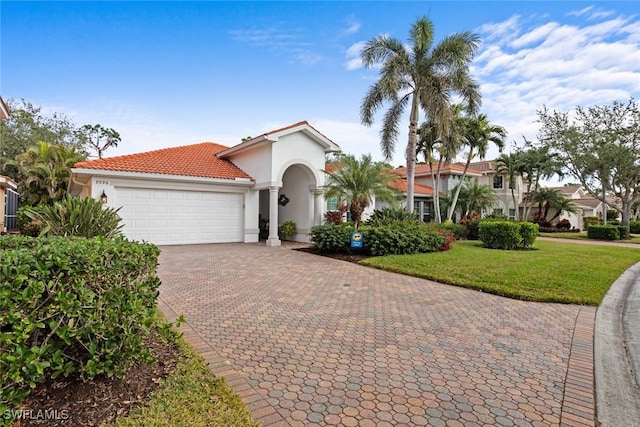 mediterranean / spanish-style house featuring a front yard and a garage