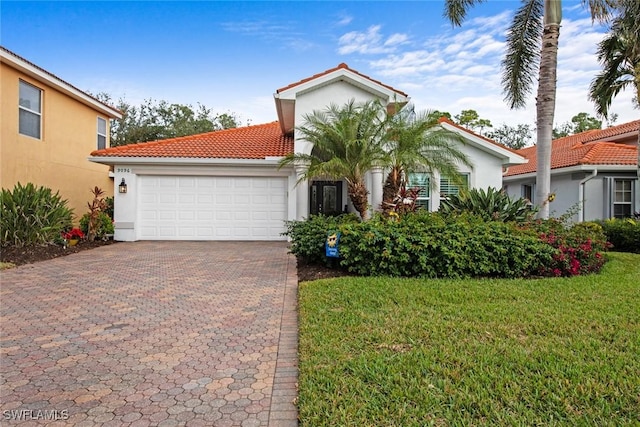 mediterranean / spanish-style home featuring a front yard and a garage