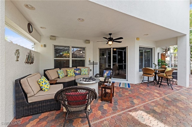 view of patio with ceiling fan and an outdoor living space with a fire pit