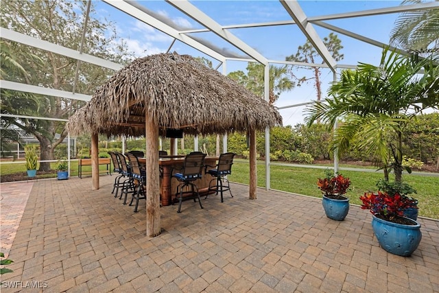 view of patio featuring an outdoor bar and a lanai