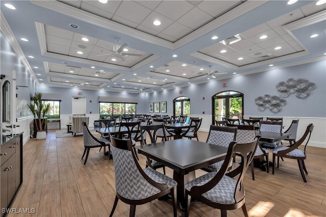 dining space featuring ceiling fan, light hardwood / wood-style flooring, crown molding, and coffered ceiling