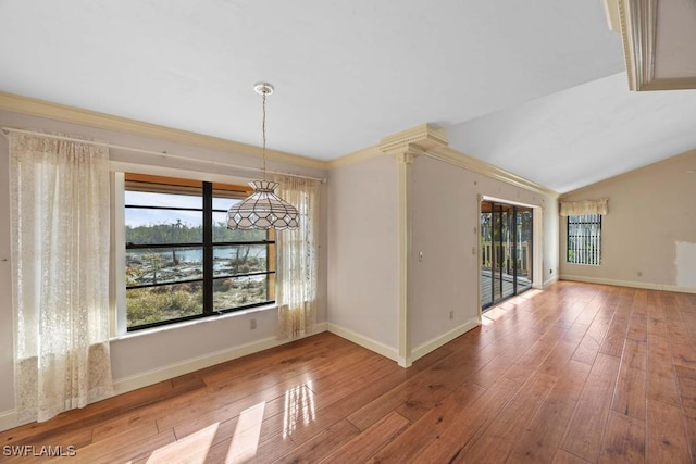 unfurnished dining area with hardwood / wood-style flooring, crown molding, and vaulted ceiling