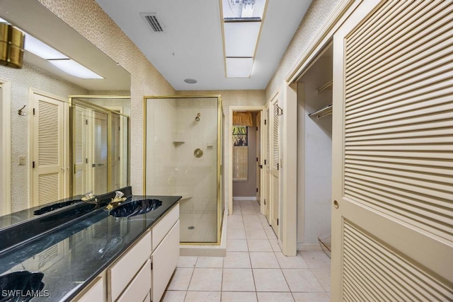 bathroom featuring vanity, tile patterned floors, and walk in shower