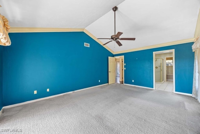 unfurnished bedroom featuring vaulted ceiling, ornamental molding, ceiling fan, light carpet, and ensuite bath