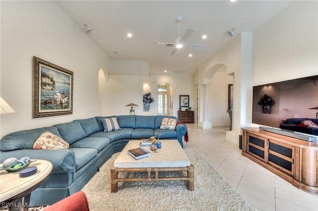 living room with ceiling fan, light tile patterned flooring, and ornate columns