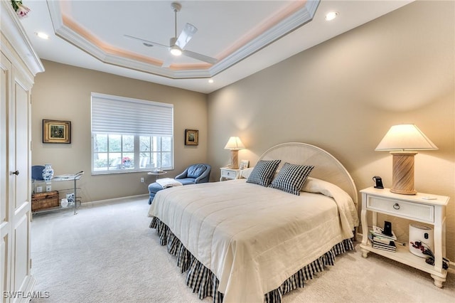 carpeted bedroom featuring ceiling fan, a tray ceiling, and crown molding