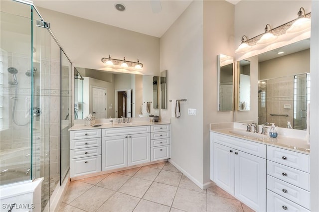 bathroom with a shower with shower door, vanity, and tile patterned flooring