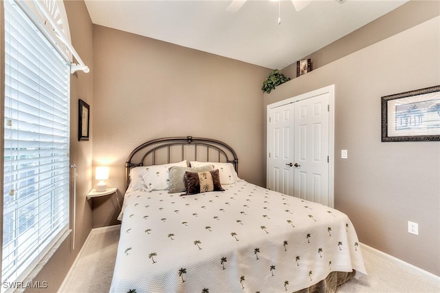 carpeted bedroom featuring ceiling fan and a closet