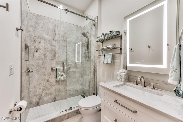 bathroom featuring a shower with door, toilet, and vanity