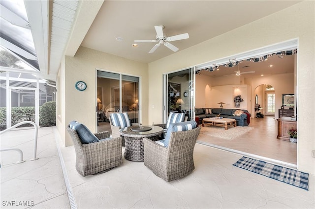 view of patio / terrace featuring a lanai, an outdoor living space, and ceiling fan